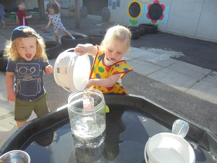 Liverpool nursery children add buckets to water play sessions